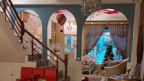 A dining area with a long table, red chairs, and a staircase leading to another level. - Venice (Taitung)