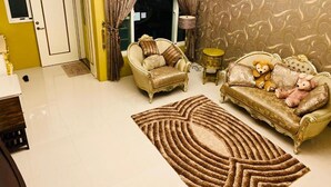 A living room with a beige sofa, a matching armchair, and a patterned rug. - Venice (Taitung)