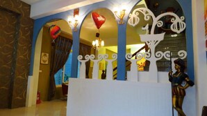 A lobby with a decorative archway, a chandelier, and a statue. - Venice (Taitung)