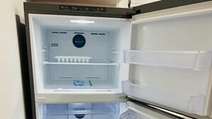 Een moderne koelkast met verschillende vakken, waaronder een vriesvak, hoofdcompartiment en een ijs- en waterdispenser.