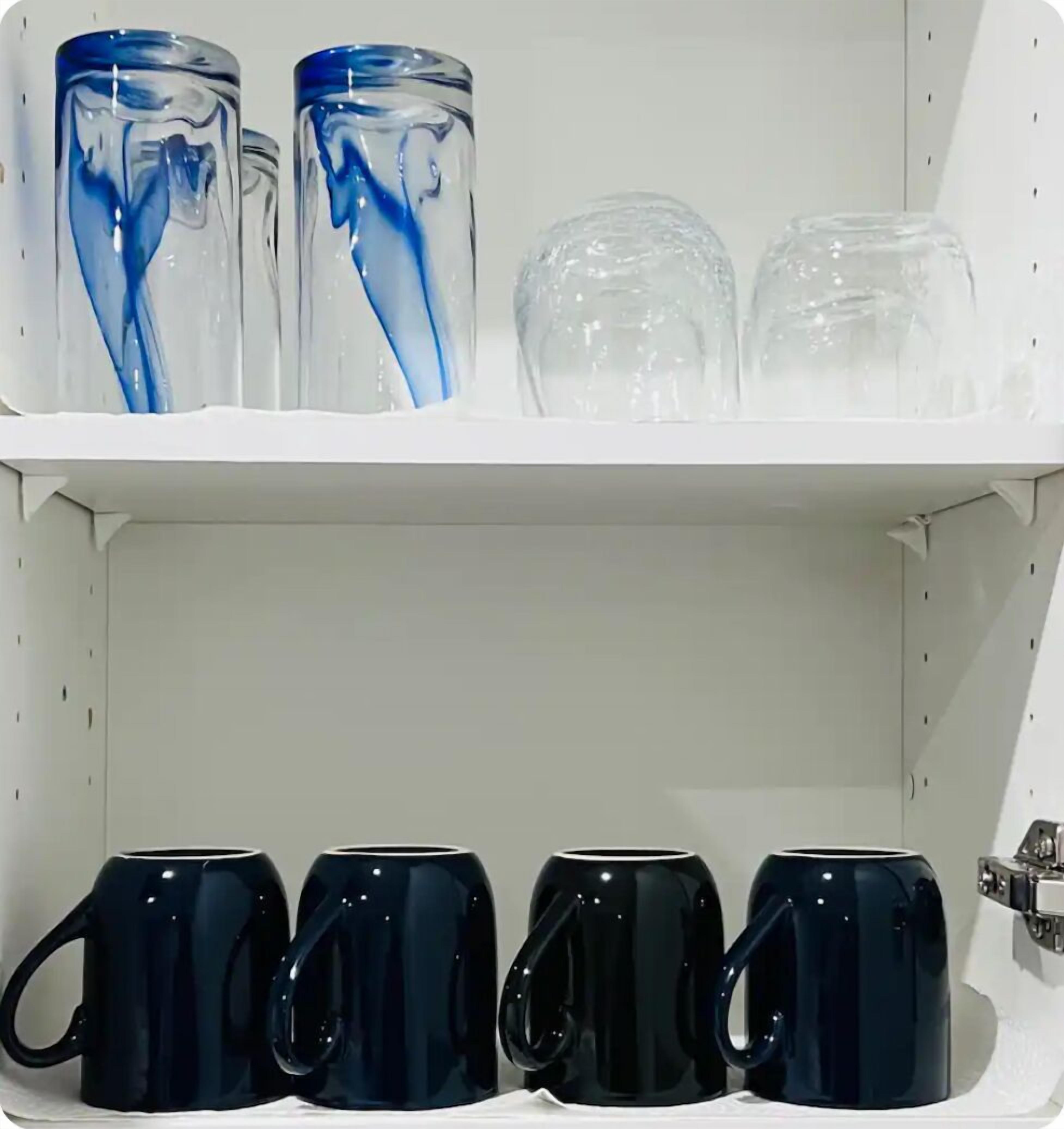 Une étagère avec divers récipients en verre et tasses.