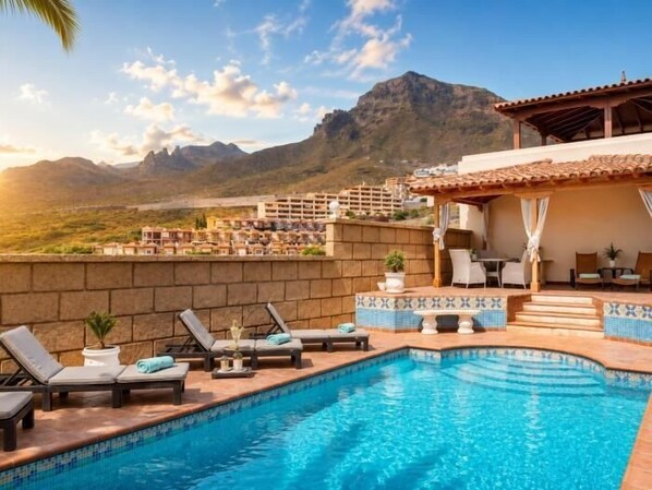 A swimming pool with lounge chairs, a pergola, and a mountain view.
