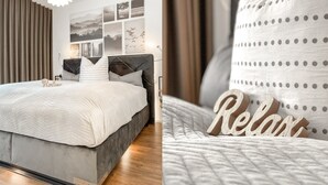 Quarto moderno com cama, cabeceira e luminária fixada na parede.