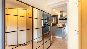 Uma cozinha moderna com uma ilha central, uma área de refeições e uma porta de vidro deslizante que dá para um quarto.