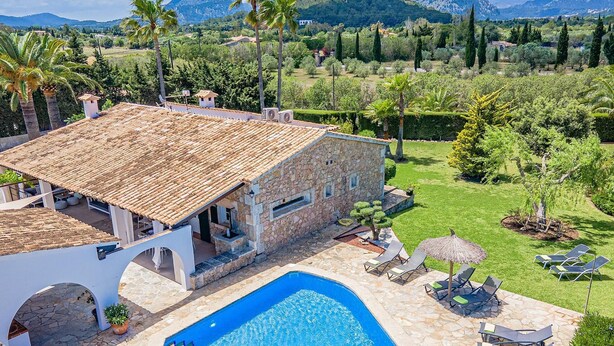 Une villa en pierre dotée d’une piscine, d’un espace extérieur aménagé et offrant une vue sur le paysage environnant.