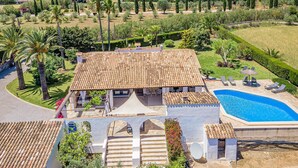 Une villa avec piscine, entourée d’une végétation luxuriante et avec des montagnes en toile de fond.