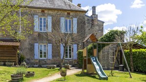 A stone house with a wooden deck, a slide, and a garden. - Beautiful holiday home with a shared pool (Dégagnac)