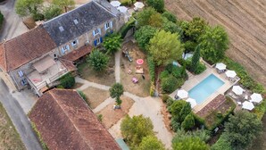 An aerial view of a property with a swimming pool, outdoor seating, and a large building with multiple windows. - Beautiful holiday home with a shared pool (Dégagnac)