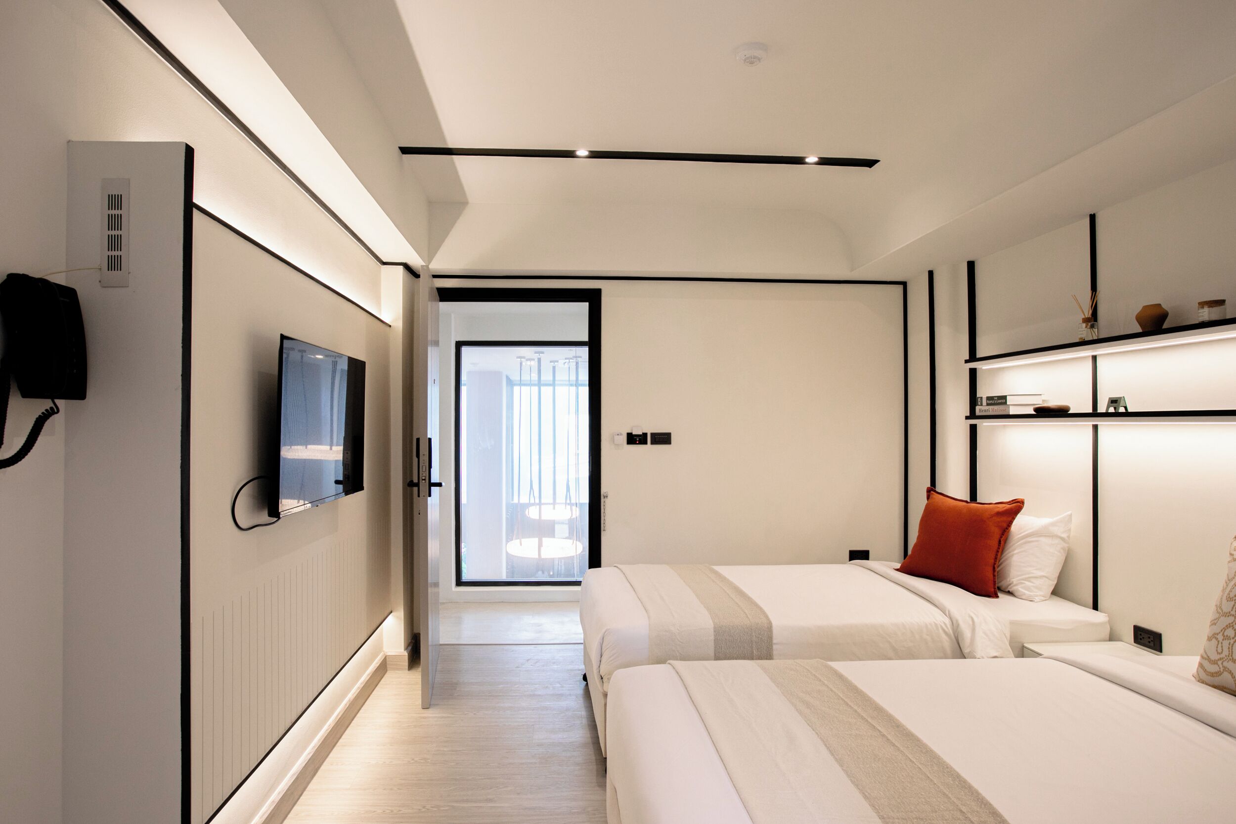 A modern hotel room with a large bed, bedside tables, a flat-screen TV, and a view of the outdoors.
