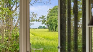 A view from a room with a door leading to a grassy field, a bench, and trees. - "Ødke" - 350m from the sea by Interhome (Odder)