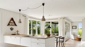 A modern kitchen with a large island, white cabinetry, and pendant lighting. - "Ødke" - 350m from the sea by Interhome (Odder)