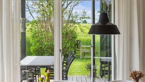 A wooden table with yellow salt and pepper shakers, a black bowl, and a glass vase with dried flowers. - "Ødke" - 350m from the sea by Interhome (Odder)