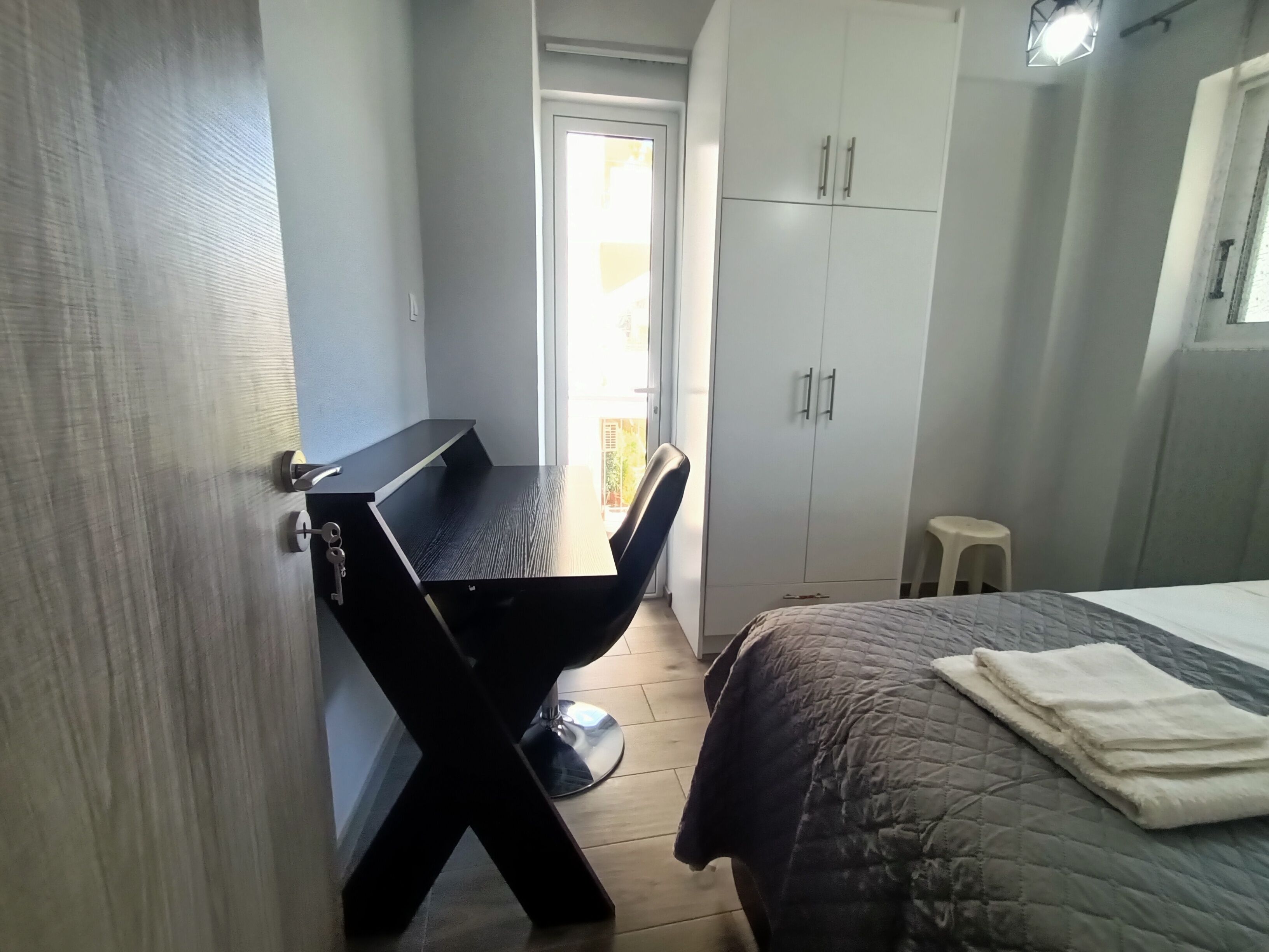 Un dormitorio pequeño con cama, escritorio y armario.