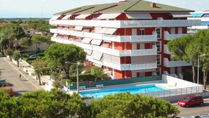 Un hôtel à plusieurs étages doté d’une piscine, de balcons et offrant une vue sur les environs.