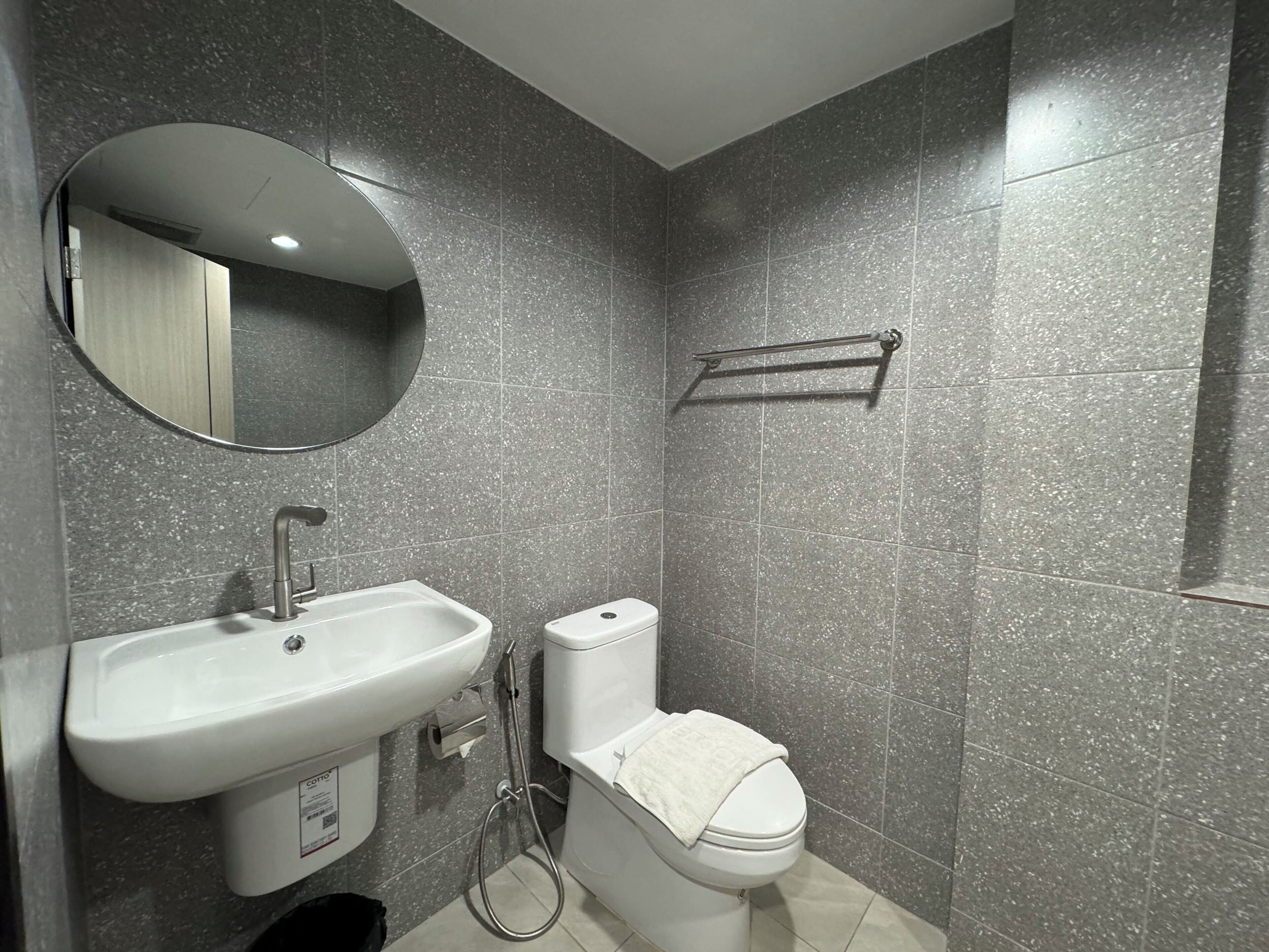 A bathroom with a white sink, a toilet, and a mirror.