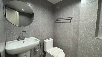 A bathroom with a white sink, a toilet, and a mirror.