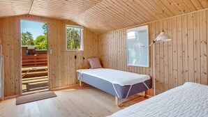 A wooden cabin room with a bed, a desk, and a window. - "Borghild" - 500m from the sea by Interhome (Gedser)