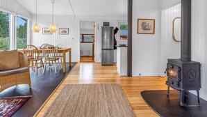 A modern interior with a dining area, kitchen, and a wood-burning stove. - "Borghild" - 500m from the sea by Interhome (Gedser)
