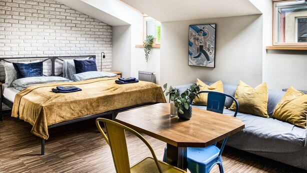A modern loft bedroom with a loft bed, a dining table, and a sofa. - Cozy Apartment with A/C for couples, City Center 2, Różana (Kraków)