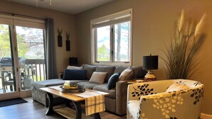 Un salon chaleureux avec un canapé, une table basse et un fauteuil à motifs.