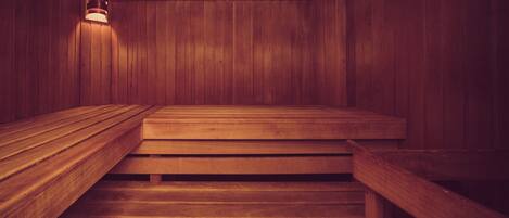 A wooden sauna with benches and a light fixture.