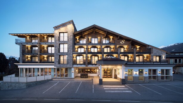 A multi-story hotel with a stone facade, balconies, and a covered entrance. - Hotel Stubai (Schönberg im Stubaital)