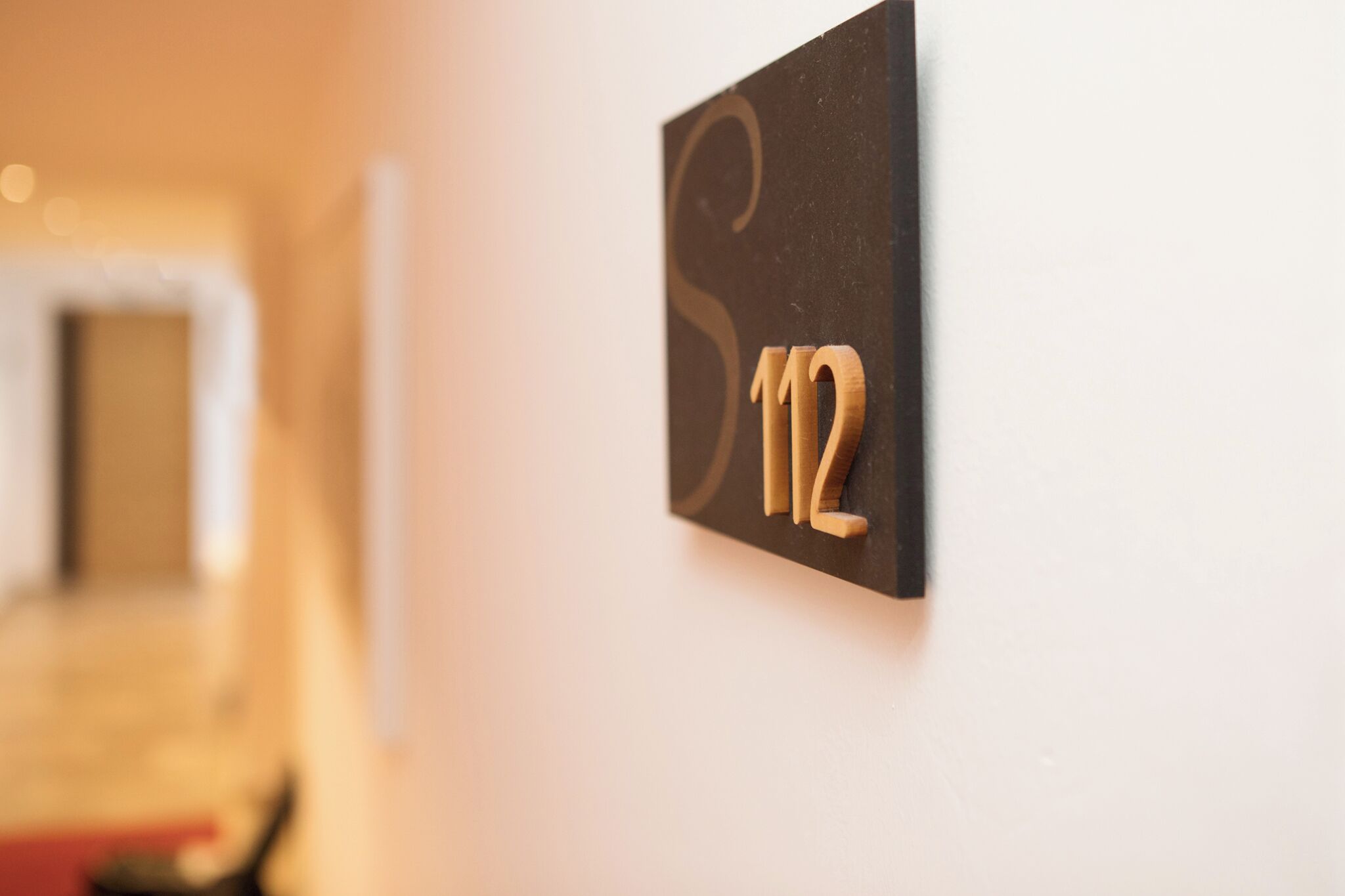 A close-up of a room number sign, '12', mounted on a wall.