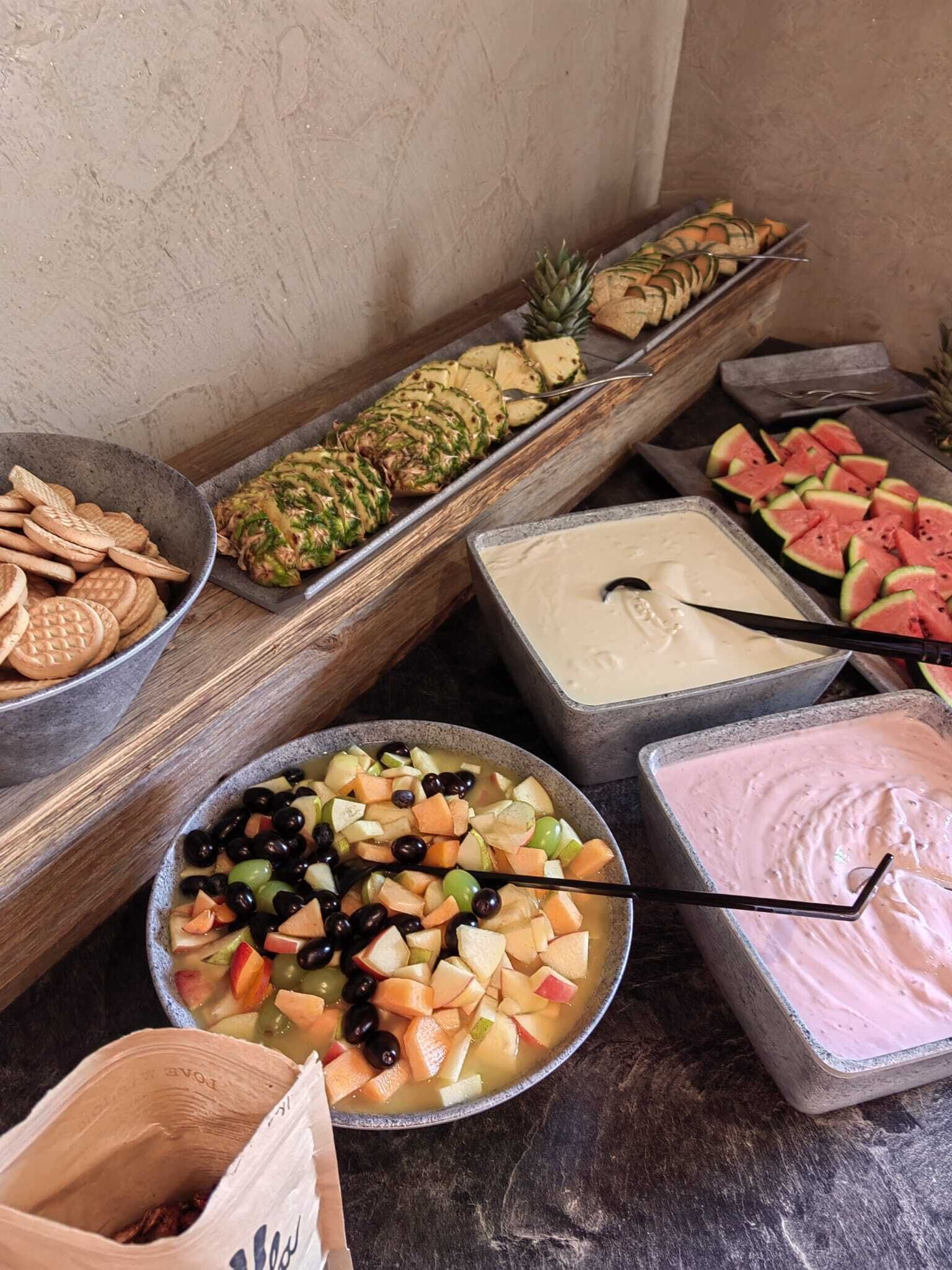 Un buffet con diverse portate, tra cui frutta, verdura e salse.