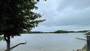 Une vue sur le lac, avec une jetée qui s’avance dans l’eau, entourée d’arbres et d’une zone herbeuse.