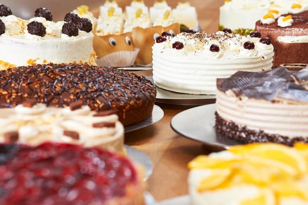 Variedad de pasteles y postres sobre una mesa.