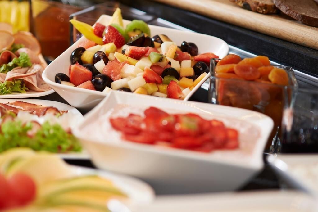 Un buffet proposant une variété d’aliments, notamment des fruits, des légumes et des viandes.