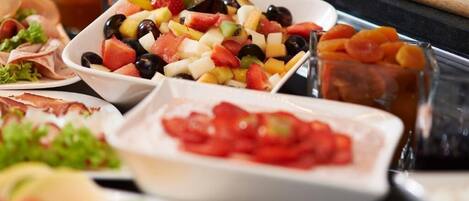 Un buffet proposant une variété d’aliments, notamment des fruits, des légumes et des viandes.