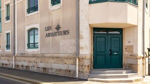 A building with a sign reading "LES ARMATEURS" and a green double door.