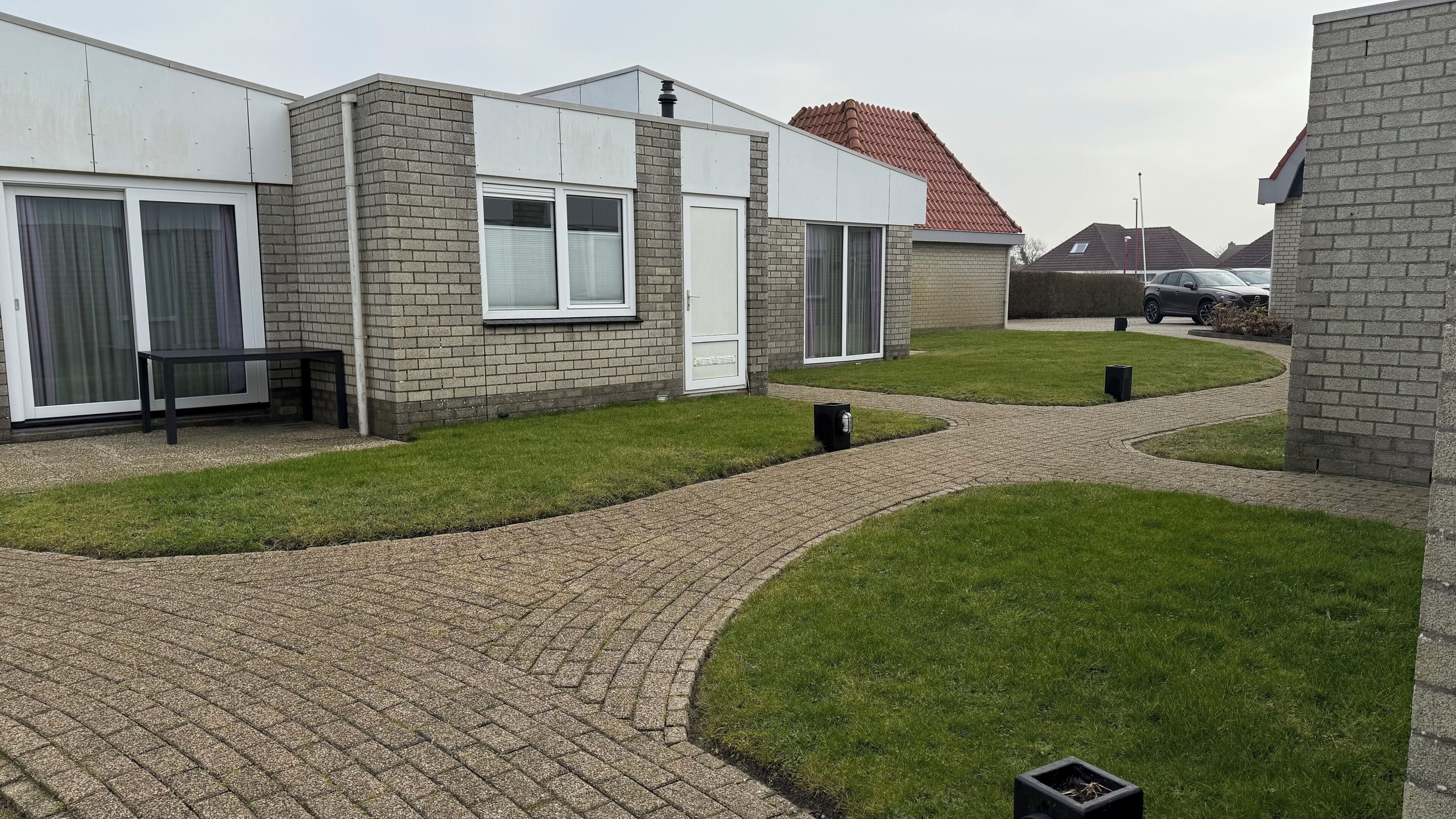 Een woonwijk met moderne huizen, verharde paden en keurig onderhouden gazons.