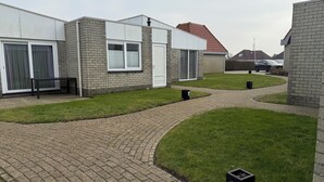 A residential area with modern houses, paved pathways, and well-maintained lawns.
