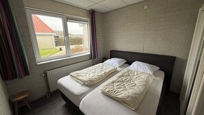 A twin room with two beds, a window, and a radiator.