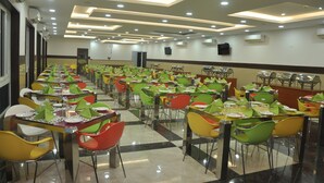 A cafeteria with multiple tables and chairs, arranged in rows. - Green Royale Resorts (Tarangambadi)