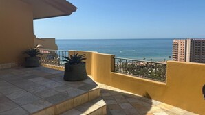 A balcony with a view of the sea, potted plants, and a tiled floor. - 8th Floor Penthouse with View of Sea in Resort with 8 Pools (Puerto Peñasco)