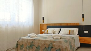 A neatly arranged bedroom with a bed, pillows, and a bedside table.
