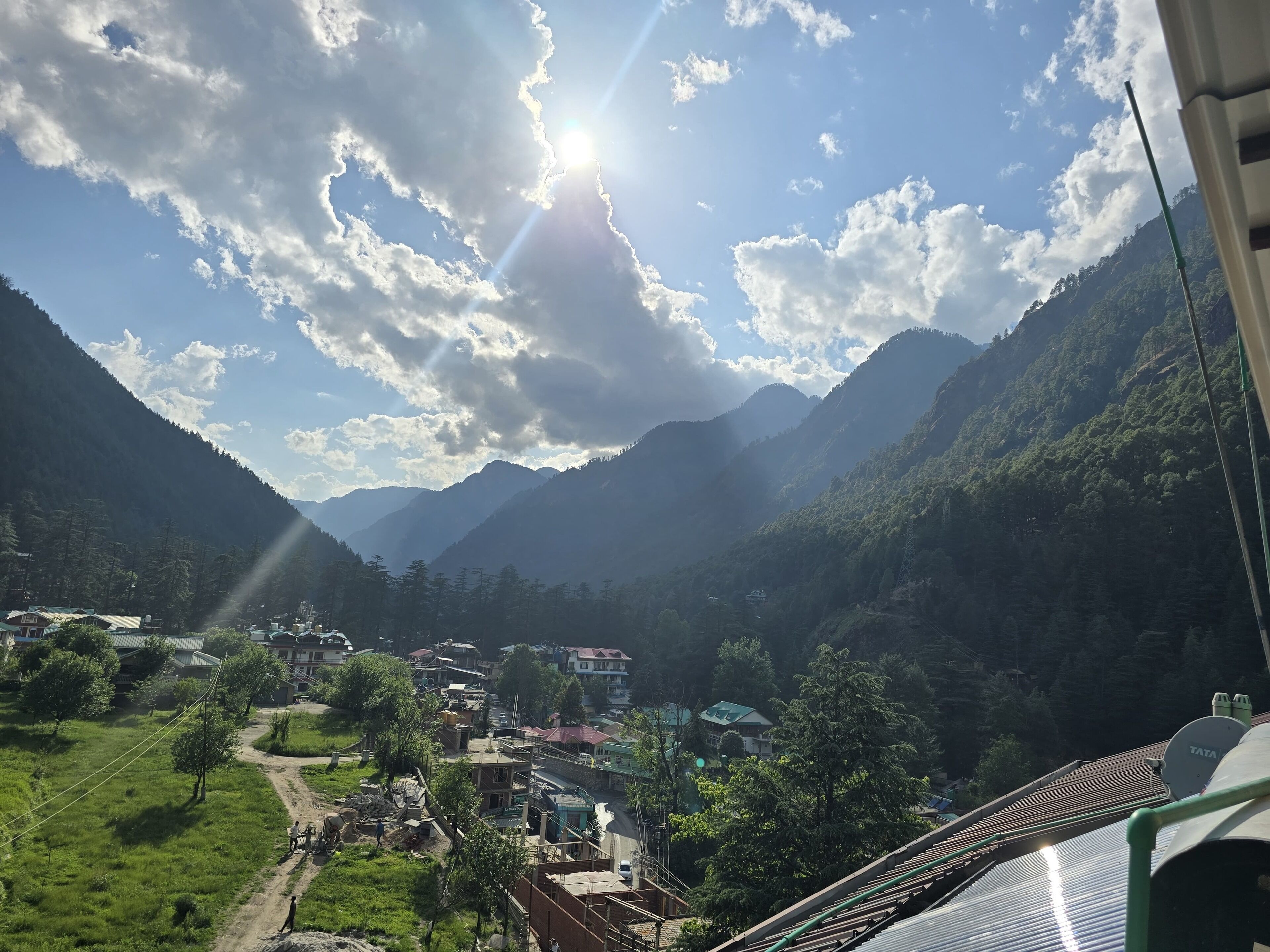 A mountainous landscape with a village, houses, and a road.