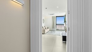 Et moderne hotelværelse med et stort vindue, et fladskærms-tv, en sofa og et lille bord.