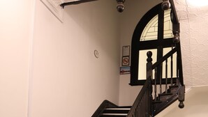 A staircase with black railings and a white door at the bottom.