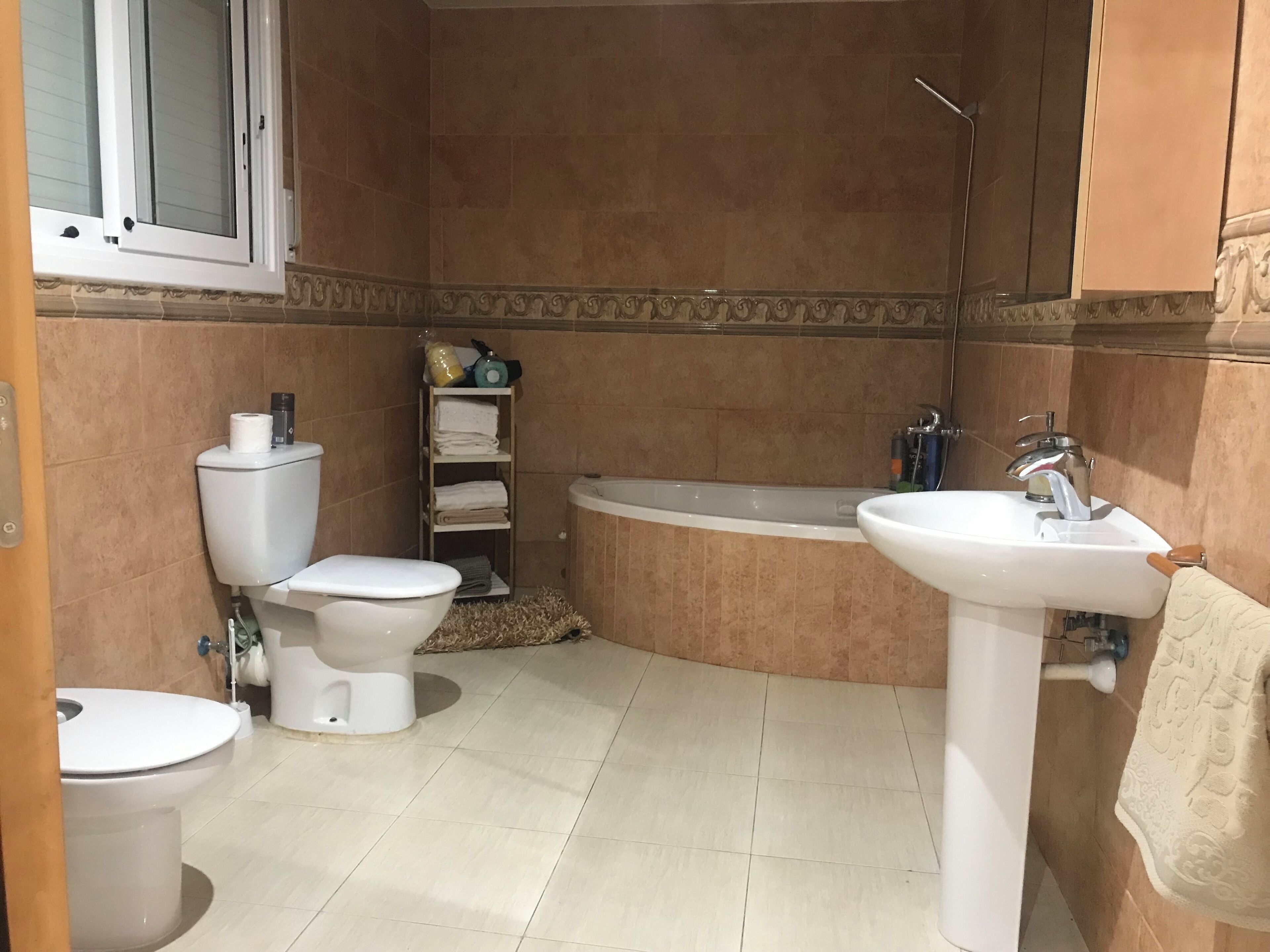 Un baño con inodoro, lavamanos y bañera.