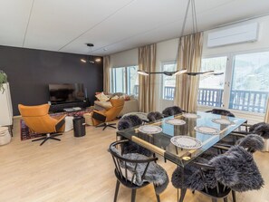A modern living room with a glass dining table, leather chairs, a sofa, and a flat-screen TV. - Casa krogerus ruka by Interhome (Kuusamo)
