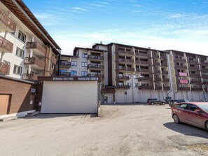 A multi-story residential building with balconies and a parking area. - Casa krogerus ruka by Interhome (Kuusamo)