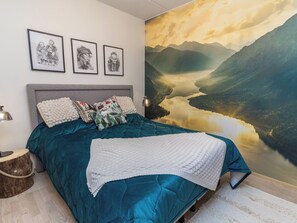 A bedroom with a large bed, a headboard, and a wall mural of a landscape. - Casa krogerus ruka by Interhome (Kuusamo)