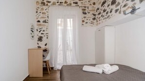 Un dormitorio con cama, escritorio y silla.