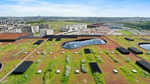 Un complex modern d'edificis amb sostres verds i panells solars.