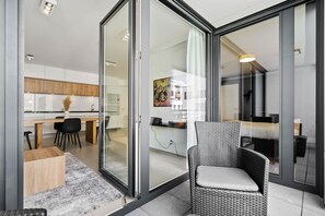 Una cocina moderna con armarios blancos, una mesa de comedor y sillas negras.