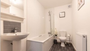 Un bagno moderno con una vasca freestanding, un lavabo sospeso e un water.